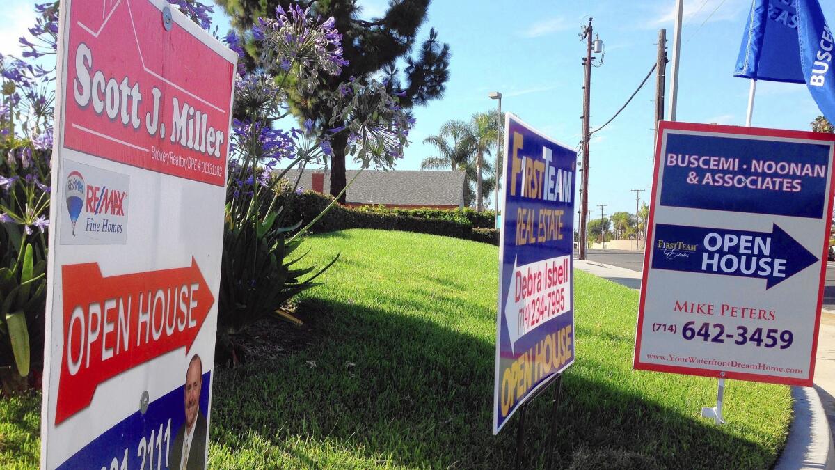 Signs direct home shoppers to open houses in Huntington Beach in June 2014.