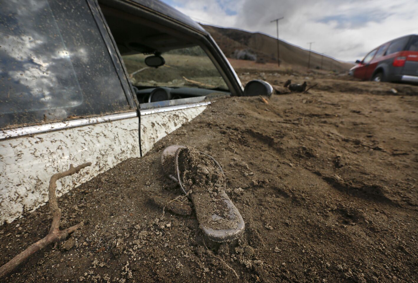 A sandal is left behind where a car was buried up to the windows in a mudslide on Elizabeth Lake Road.
