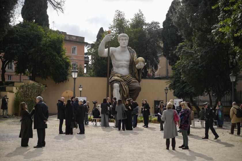 Visitantes admiran la réplica de la estatua colosal del emperador romano Constantino, de 13 metros de altura, encomendada por él en 312 d.C. y reconstruida por medio de tecnología 3D a partir de escaneos de las nueve partes originales de mármol que aún existen, al ser develada en Roma el martes 6 de febrero de 2024. (AP Foto/Andrew Medichini)