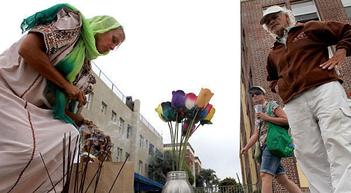 Lisa Green and Toneey Acevedo stop to place remembrances at a makeshift memorial on the Venice boardwalk.
