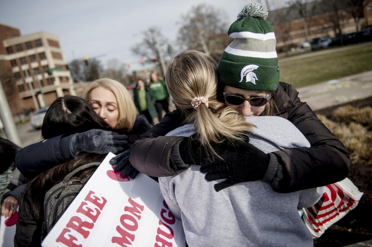 A woman embraces a student with a "free hug from a mom" at Michigan State University in East Lansing, Mich.