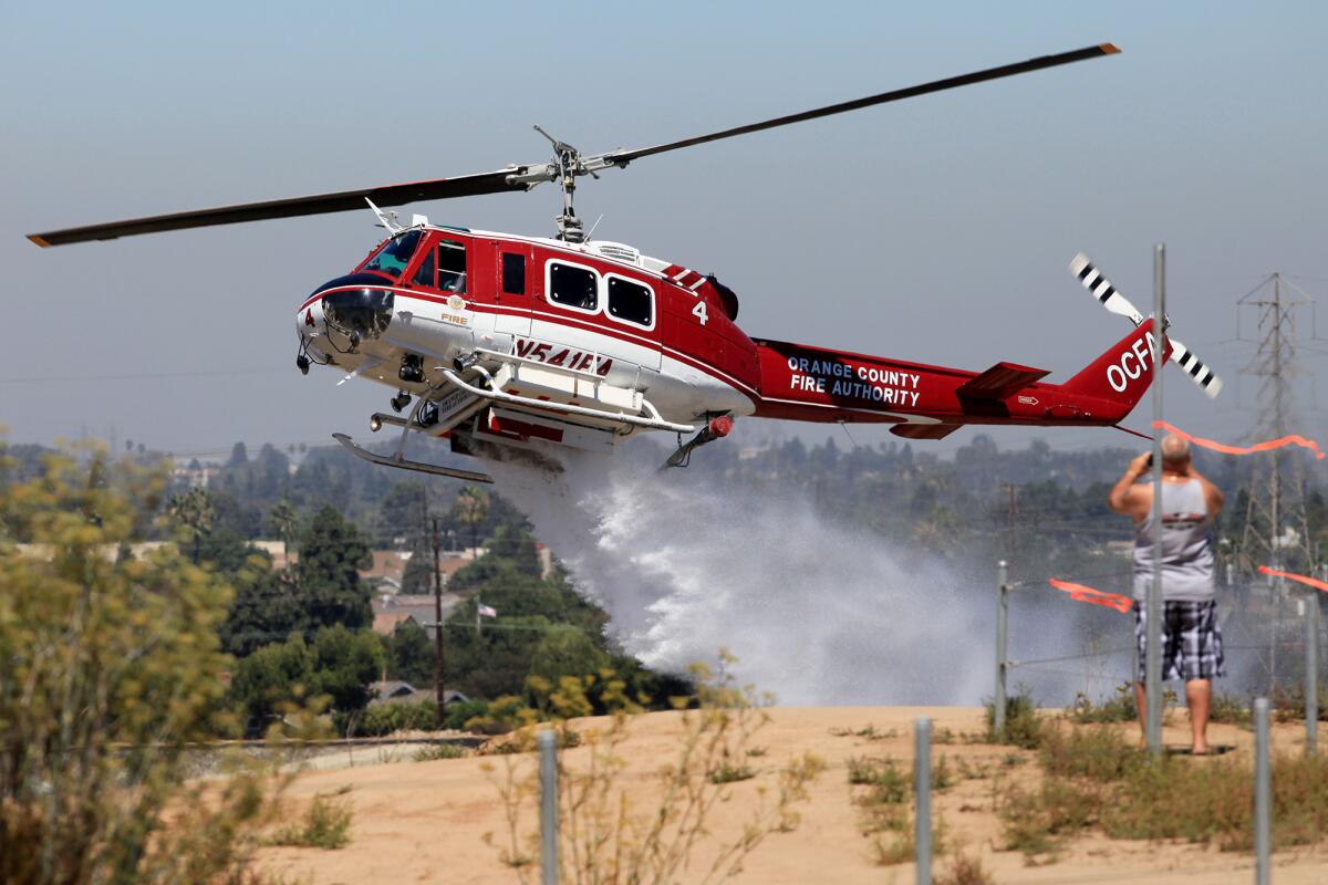 An Orange County Fire Authority helicopter participates in the first day of a three day fire training exercise with members of the Costa Mesa Fire Department at Fairview Park in Costa Mea on Thursday. The helicopter, flown by OCFA fire pilot Ethan Jensen, can hold up to 360 gallons of water.