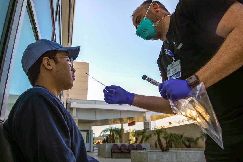 A registered nurse administers a coronavirus PCR test