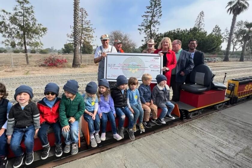 County Supervisor Katrina Foley, right, presented a check for $15,000 to the O.C. Model Engineers Thursday at Fairview Park to help them rebuild after an act of vandalism.