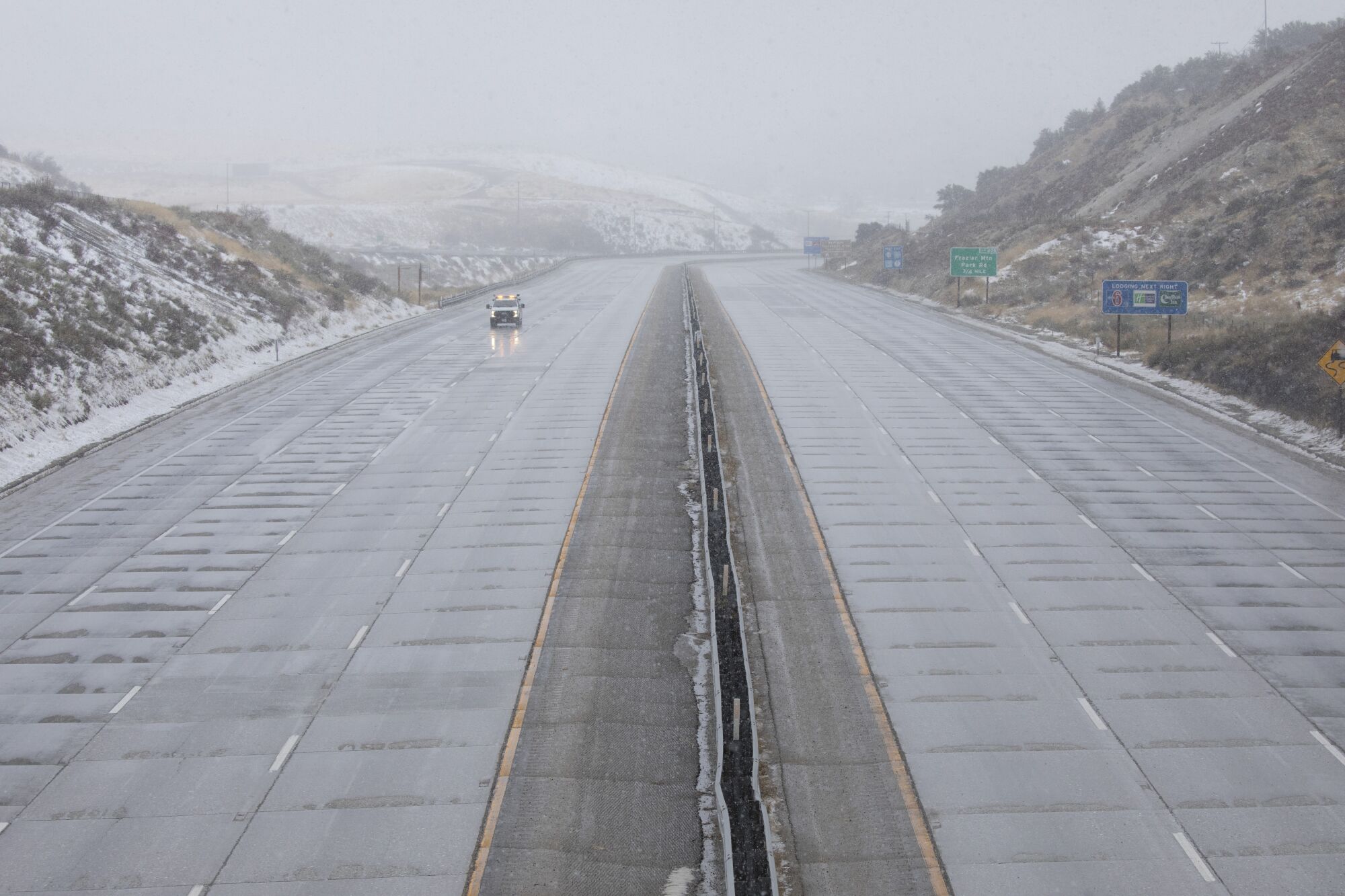 A Caltrans vehicle drives on an empty stretch of the 5 Freeway through Gorman as a series of winter storms hit California.