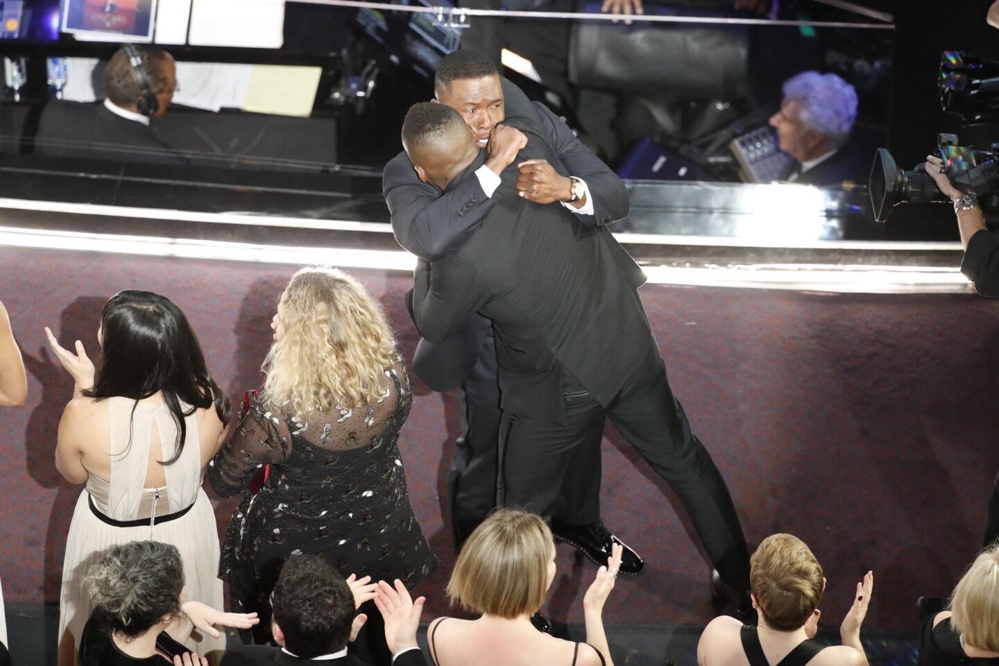 "Moonlight" cast members Mahershala Ali and Trevante Rhodes hug after winning Best Picture for "Moonlight."