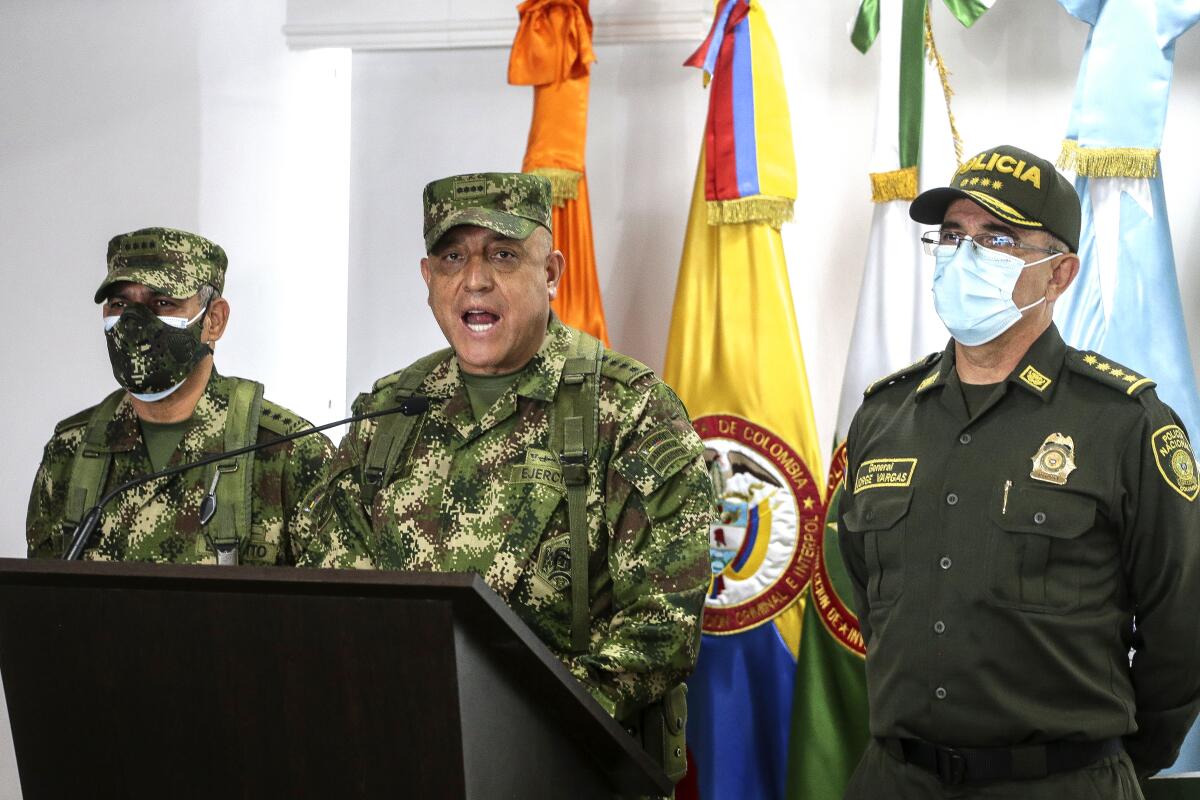 Three military officers in uniform at a news conference