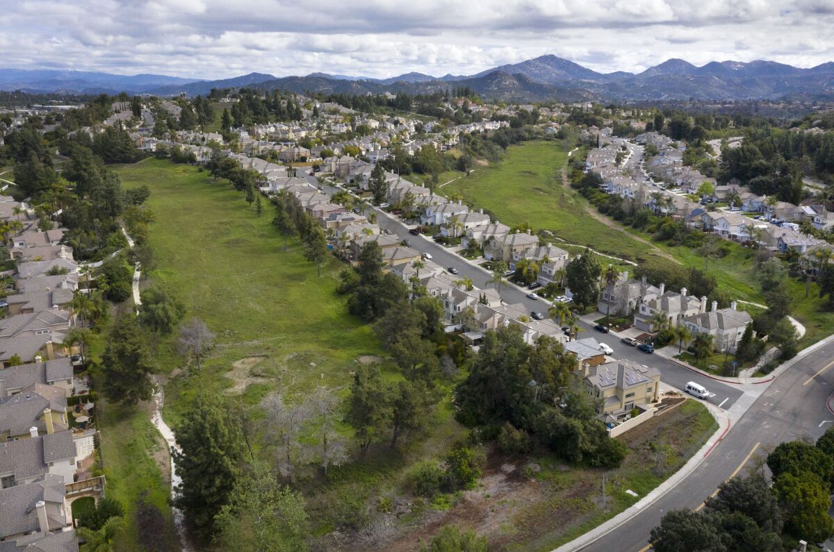 An aerial view of a golf course surrounded by homes.