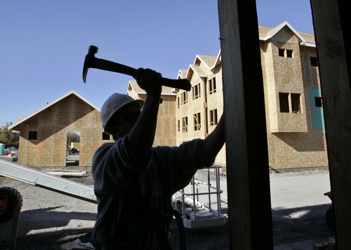 A construction worker wields a hammer at a condo development site