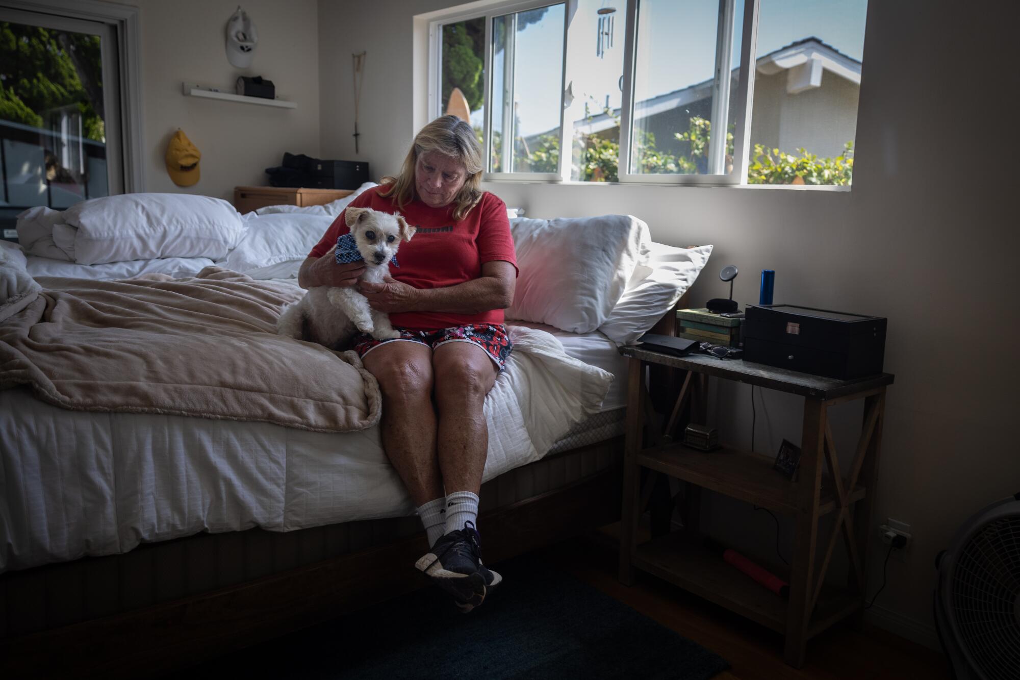 Patty Perkinson y su perro Nike sentados junto a su cama