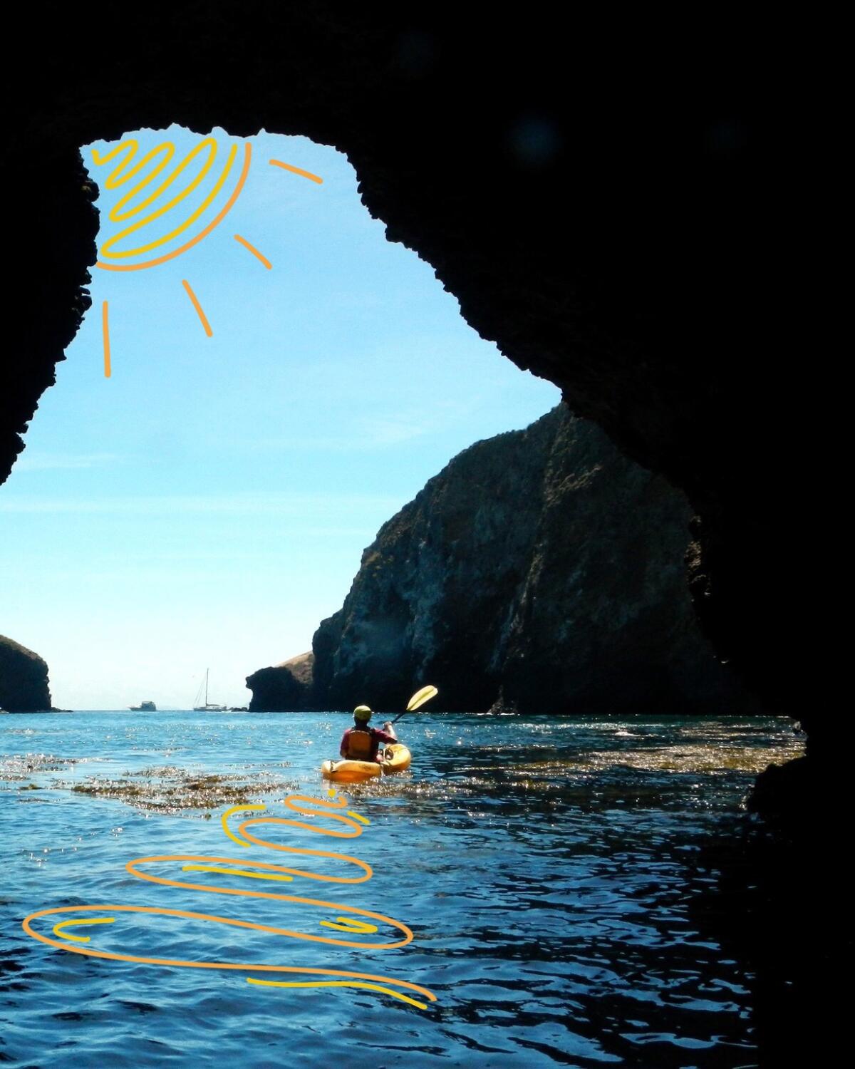 A kayaker paddles through a natural tunnel east of Scorpion Anchorage on Santa Cruz Island.