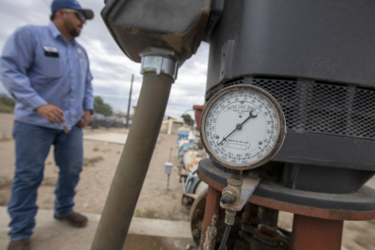 City of Needles water operator Taylor Miller stands at the the main water supply 