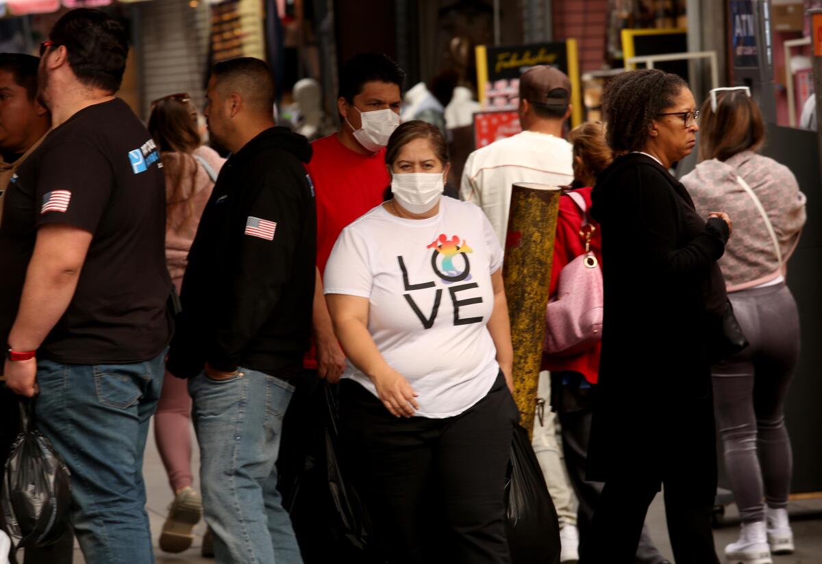 Dec. 6. photo of shoppers, some wearing masks, some not, make their way along Santee Alley in Los Angeles.