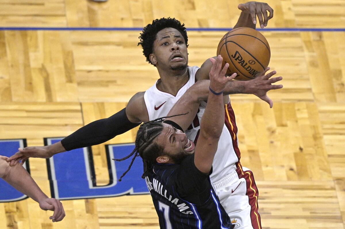 Miami Heat forward KZ Okpala (4) blocks a shot by Orlando Magic guard Michael Carter-Williams (7) during the second half of an NBA basketball game on Sunday, March 14, 2021, in Orlando, Fla. (AP Photo/Phelan M. Ebenhack)