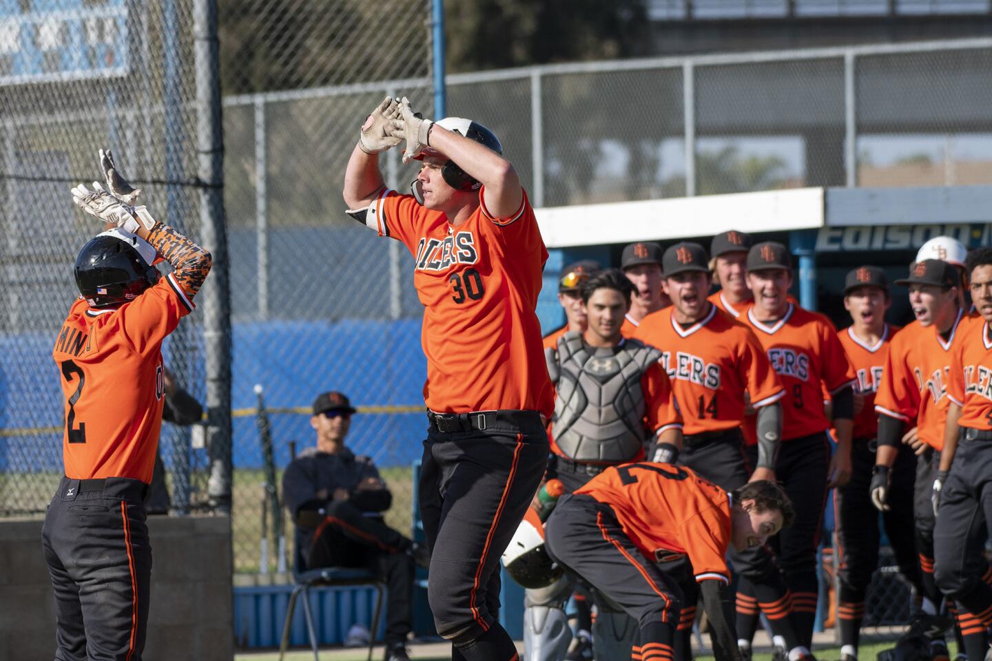 Huntington Beach's Justin Brodt gets a high five from Cole Minato after hitting a two-run home run in the sixth inning against Fountain Valley's Jake Brooks during a Sunset League game on Friday, April 27.