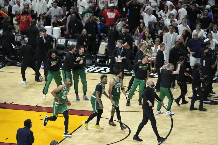 Boston Celtics players celebrate after the Celtics beat the Miami Heat 104-103 during Game 6 of the NBA basketball Eastern Conference finals, Saturday, May 27, 2023, in Miami. (AP Photo/Rebecca Blackwell)