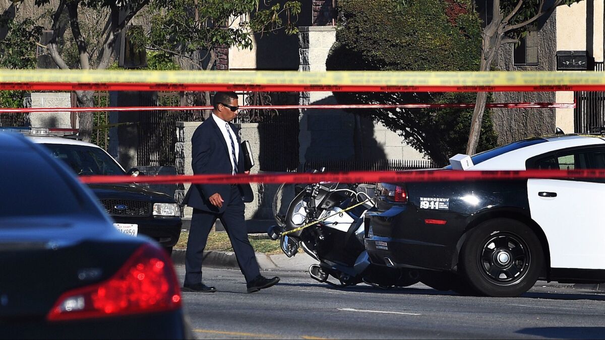 Investigators examine the scene of a shooting by Los Angeles police last summer in South L.A.