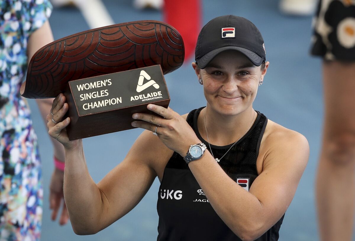 Ash Barty of Australia celebrates victory with the trophy after winning over Elena Rybakina of Kazakhstan in the final of the the Adelaide International Tennis Tournament, in Adelaide, Sunday, Jan. 9, 2022. (Matt Turner/AAP Image via AP)