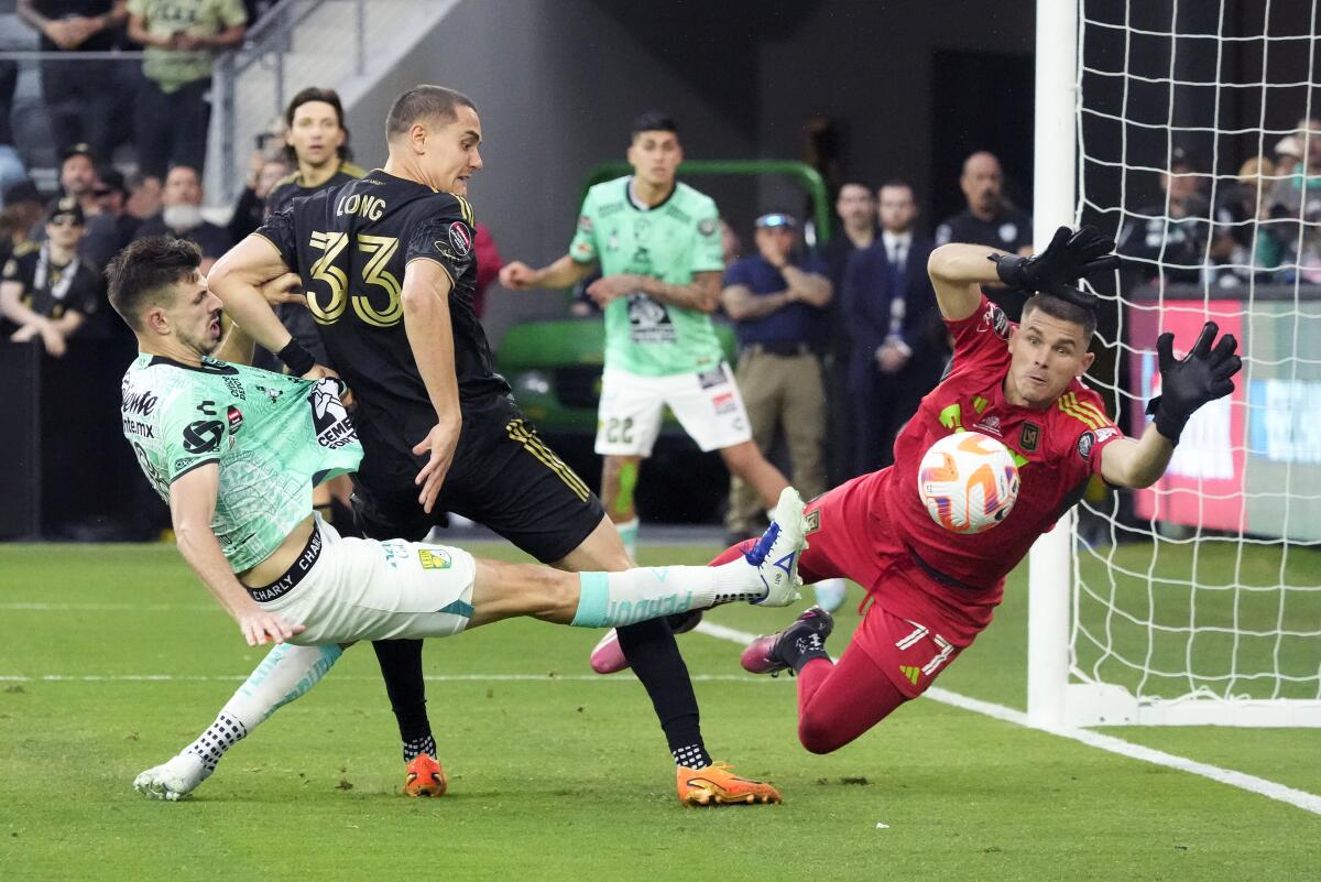 LAFC goalkeeper John McCarthy and defender Aaron Long try to stop a shot by León midfielder Lucas Di Yorio.