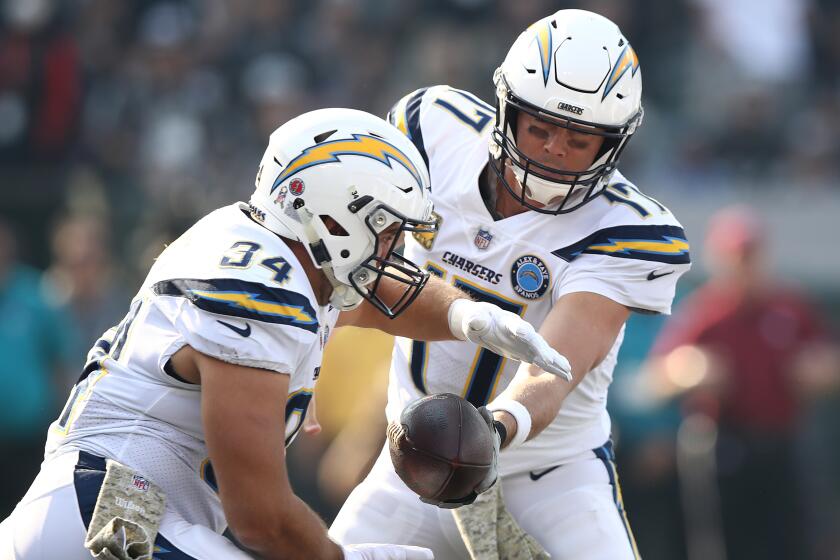 OAKLAND, CA - NOVEMBER 11: Philip Rivers #17 of the Los Angeles Chargers hands the ball off to Derek Watt #34 during their NFL game against the Oakland Raiders at Oakland-Alameda County Coliseum on November 11, 2018 in Oakland, California. (Photo by Ezra Shaw/Getty Images)