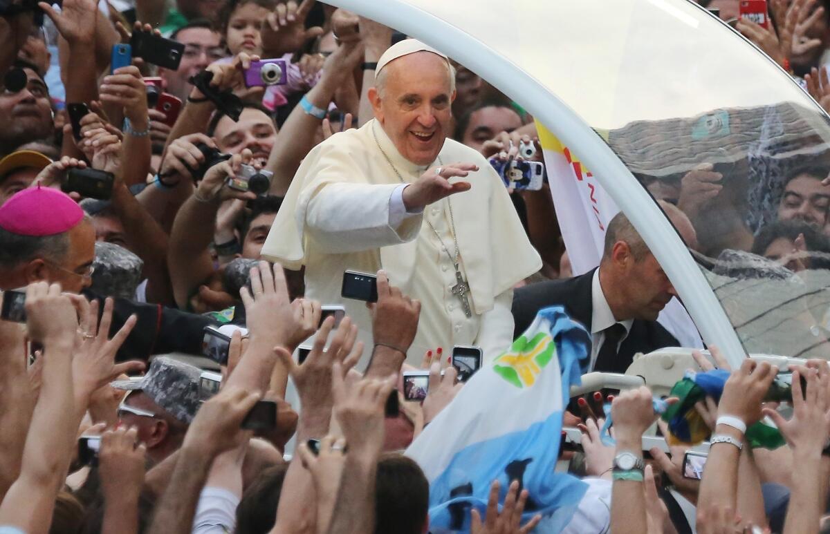 Pope Francis waves to the crowd while departing the Metropolitan Cathedral after arriving in Rio de Janeiro.