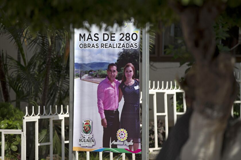 ARCHIVO - Un letrero promueve proyectos de la ciudad con el alcalde José Luis Abarca y su esposa frente a las oficinas municipales en Iguala, México, el 7 de octubre de 2014. Abarca ha sido exonerado por el secuestro de 43 estudiantes de Ayotzinapa, desaparecidos en Iguala en julio de 2014, anunció el presidente de México el miércoles 31 de mayo de 2023. (AP Foto/Eduardo Verdugo, Archivo)