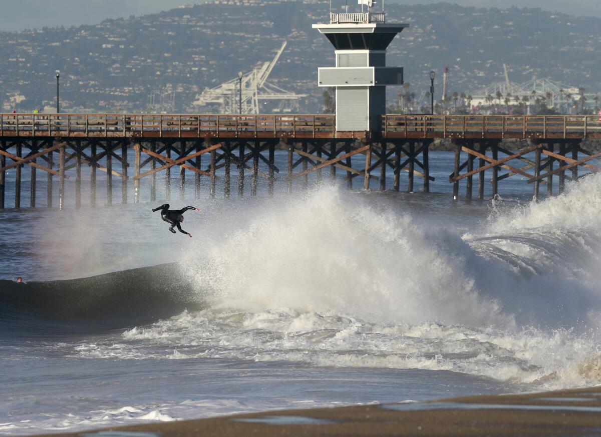 A surfer is ejected after getting a coveted tube ride as the third major El Niño storm of the season brings high surf at the Seal Beach pier Jan. 7.