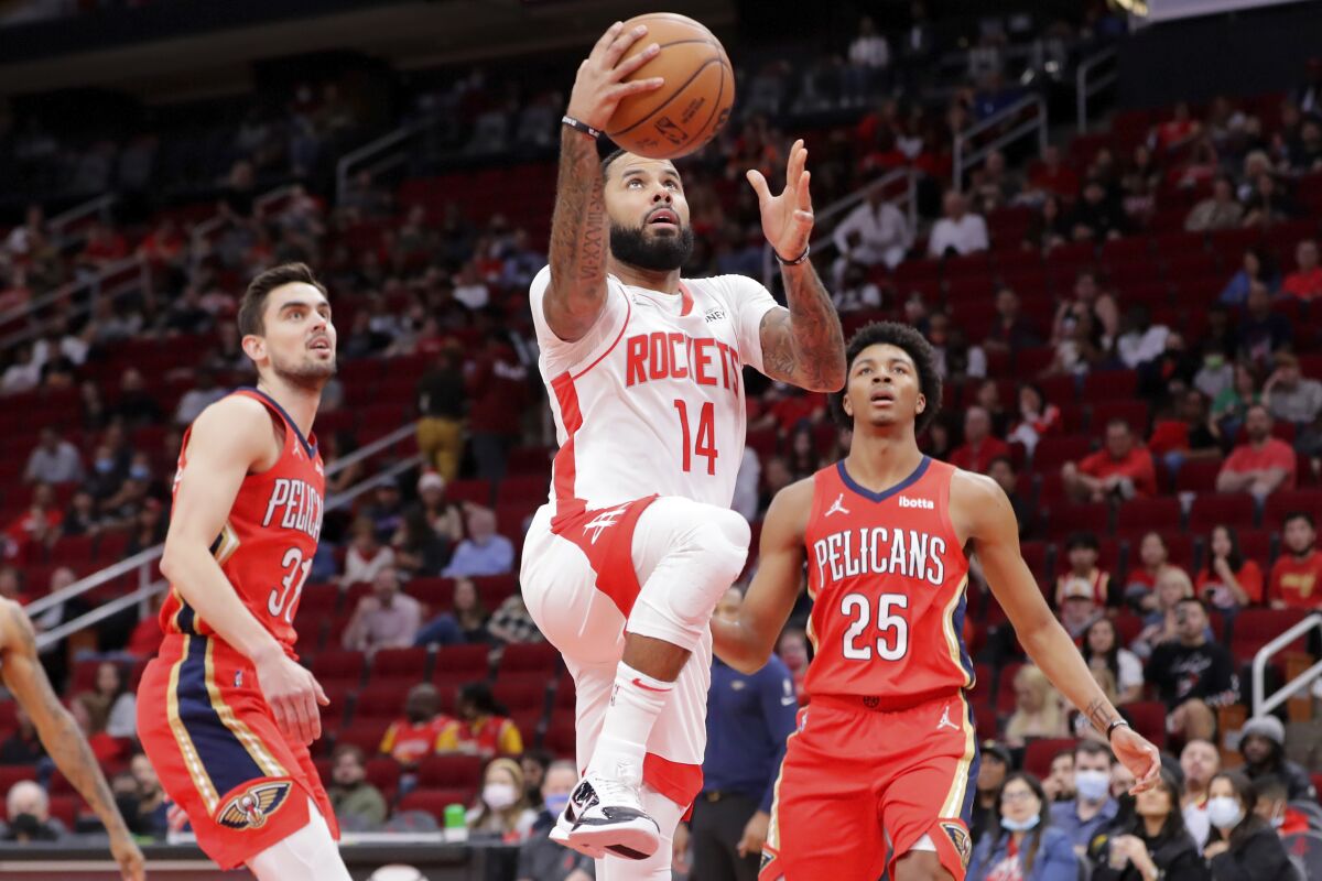 Houston Rockets guard D.J. Augustin (14) shoots between New Orleans Pelicans guards Tomas Satoransky (31) and Trey Murphy III (25) during the first half of an NBA basketball game Sunday, Dec. 5, 2021, in Houston. (AP Photo/Michael Wyke)