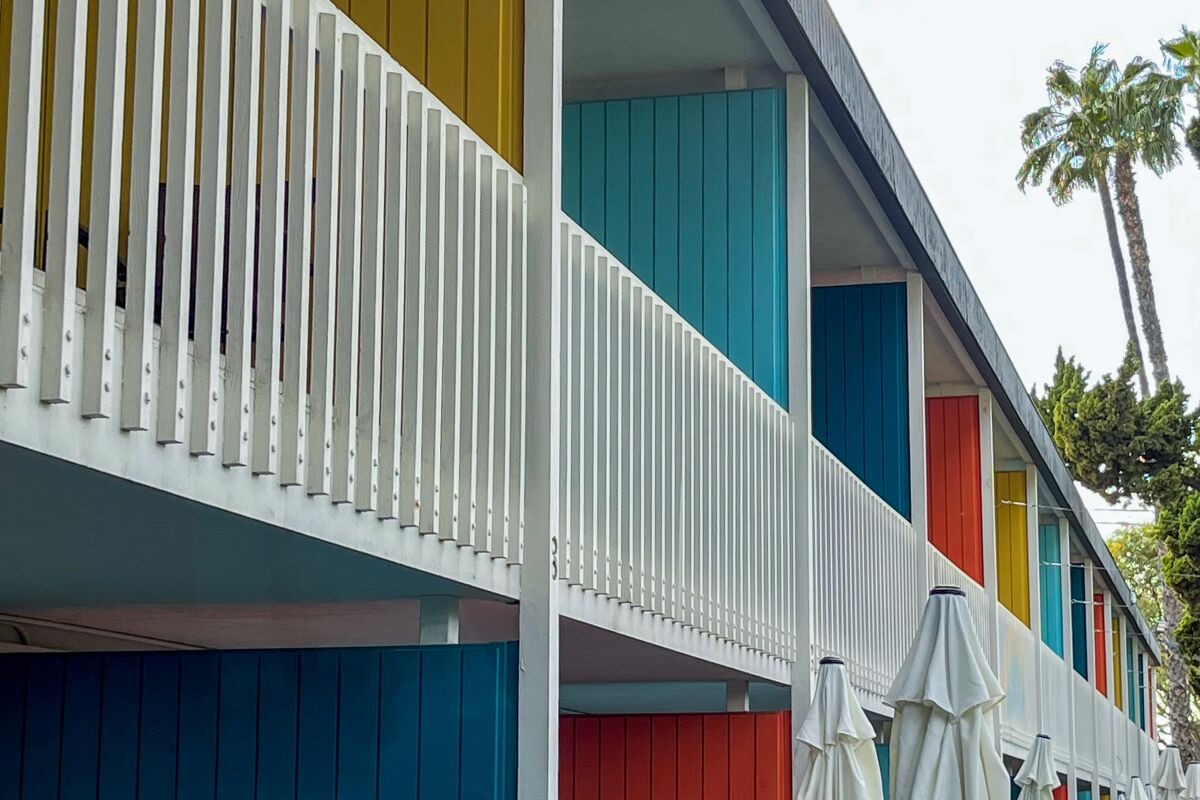 The colorful exterior façade of the Anaheim Hotel showing the second floor and white railing