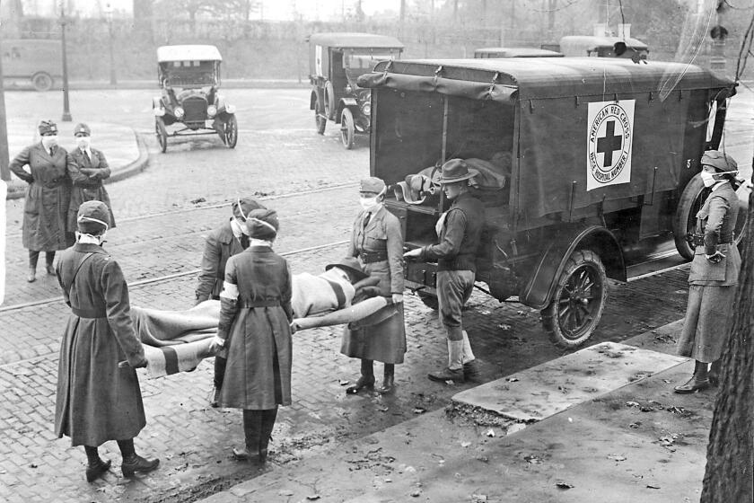Members of the American Red Cross remove Spanish influenza victims from a house at Etzel and Page avenues in 1918. (St. Louis Post-Dispatch file photo/Tribune News Service via Getty Images)