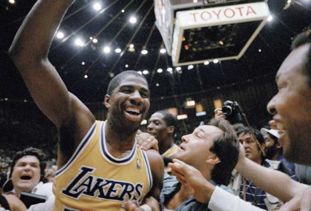 Magic Johnson celebrates with fans after the Lakers win the championship in 1987.