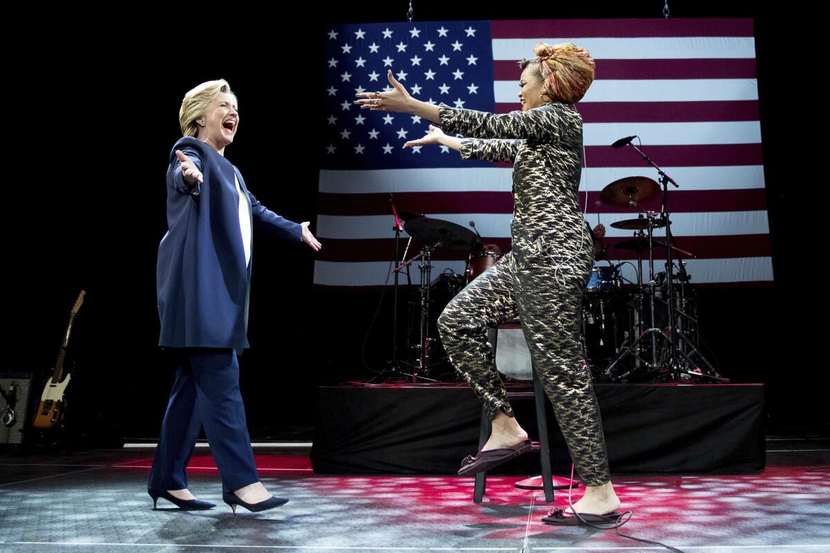 Hillary Clinton takes the stage with singer Andra Day at a fundraiser in San Francisco on Oct. 14, 2016.