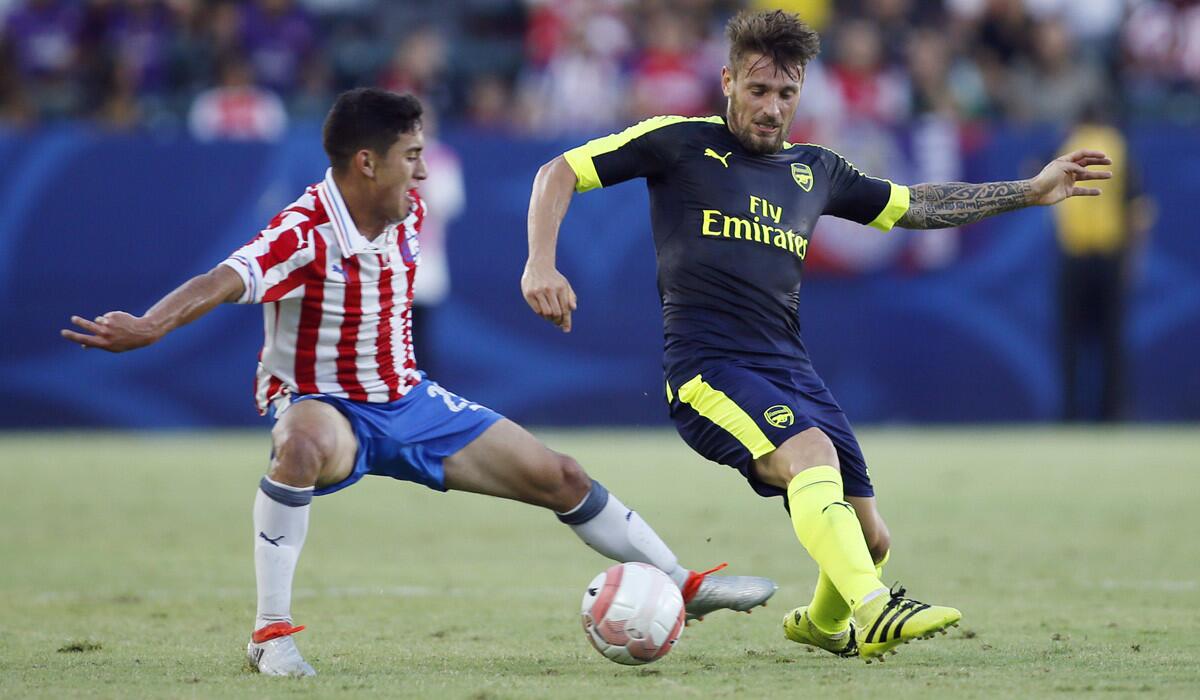 Chivas Guadalajara's Alejandro Zendejas, left, fights for the ball with Arsenal's Mathieu Debuchy during the second half of a friendly game Sunday.
