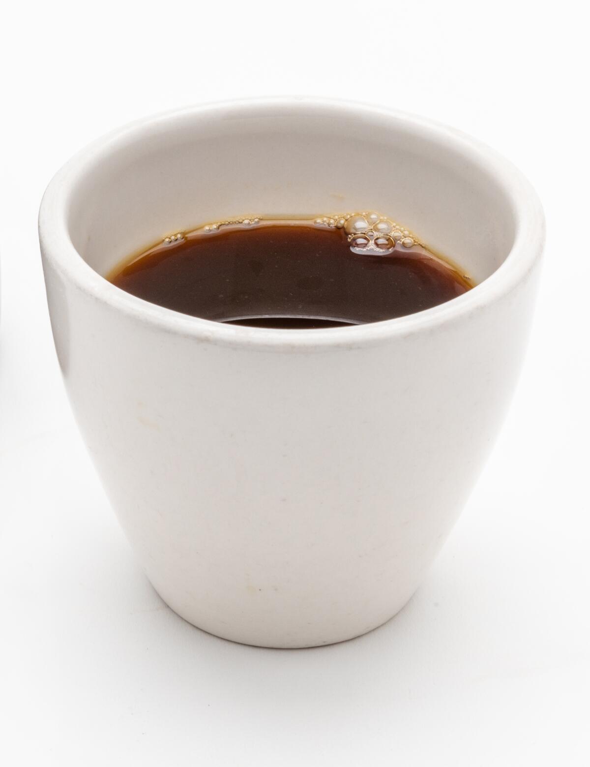 A white mug filled with black coffee.