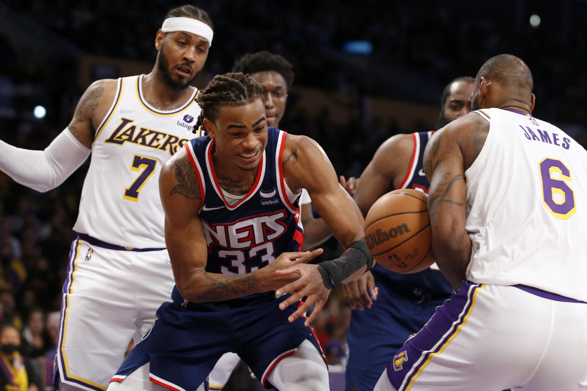 Brooklyn Nets forward Nic Claxton fights for a loose ball with Lakers forwards Carmelo Anthony, left, and LeBron James.