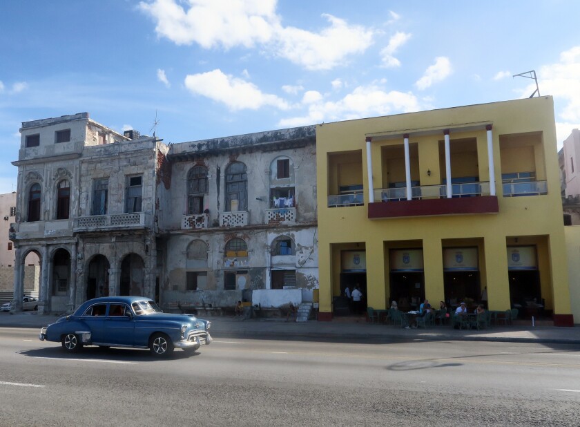 Across from Havana's famed Malecon seawall, a crumbling old home stands next to one refurbished as a privately-owned restaurant and hotel.