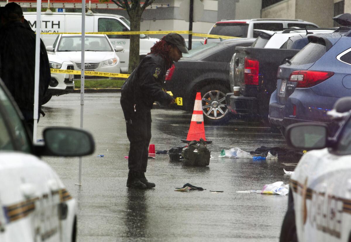 A Montgomery County police officer marks evidence after a shooting outside the Westfield Montgomery mall in Bethesda, Md., on May 6.