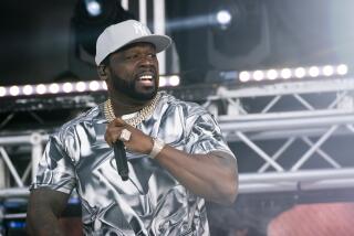 Rapper 50 Cent looks off to his left while performing onstage