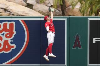 Los Angeles Angels left fielder Randal Grichuk leaps at the wall to catch a fly ball.