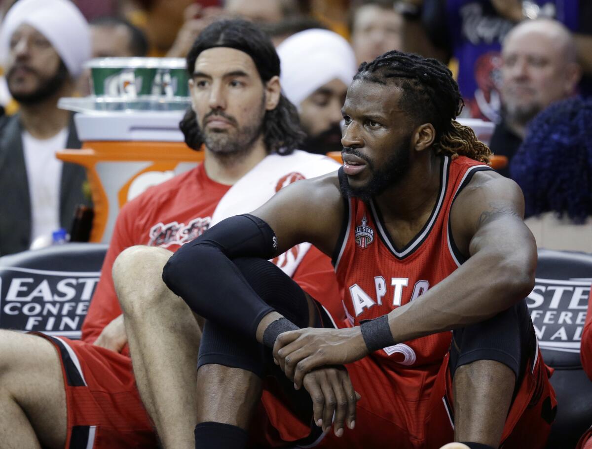 Raptors guard DeMarre Carroll, right, and forward Luis Scola sit on the bench during the second half of a Game 2 loss to the Cavaliers.