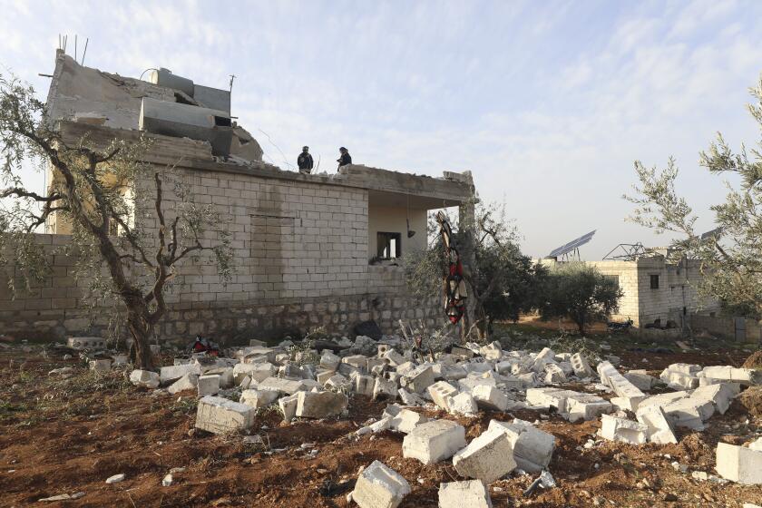 People check a destroyed house after an operation by the U.S. military in Syria, Thursday, Feb. 3, 2022. 