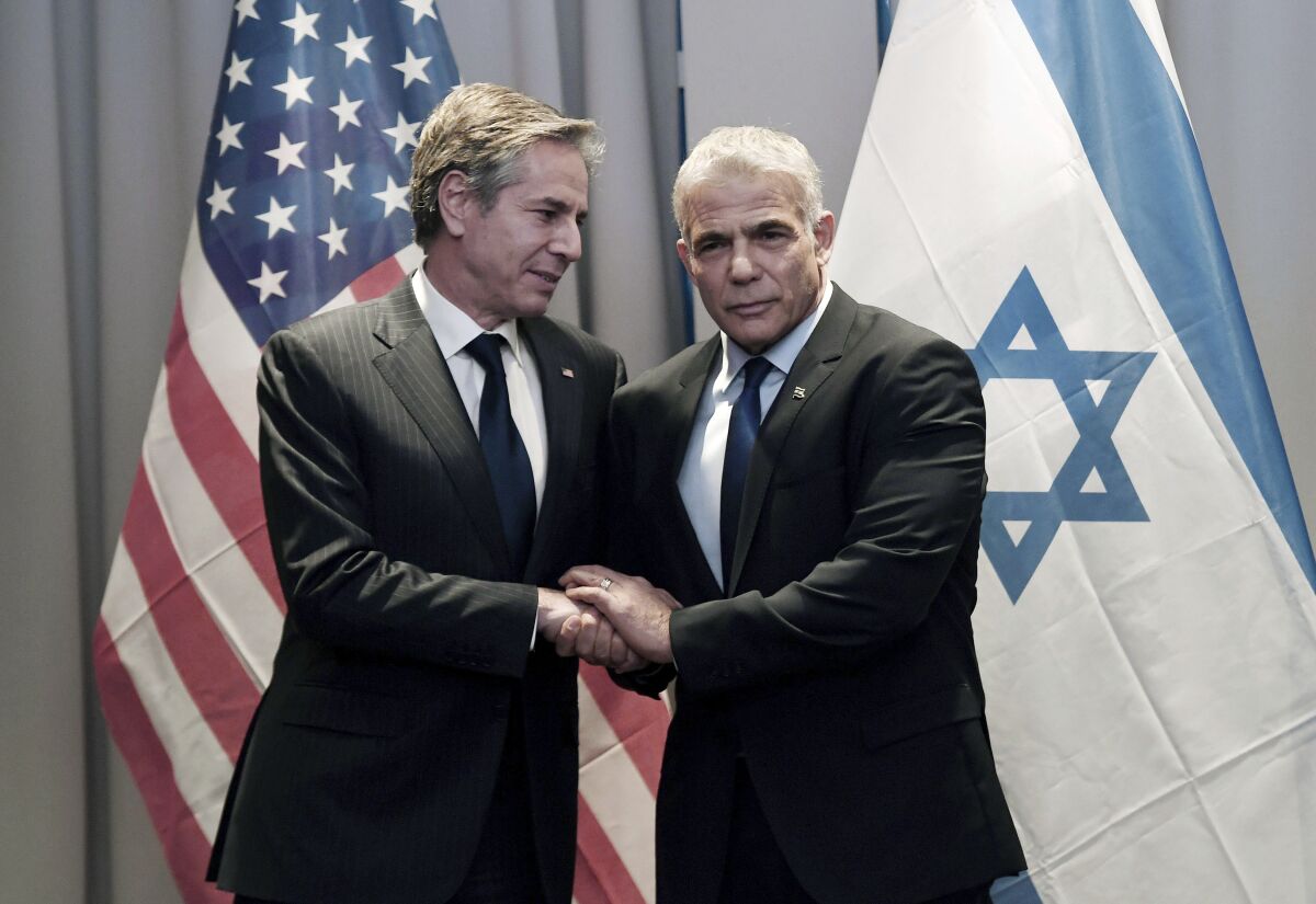 US Secretary of State Antony Blinken, left meets with Israeli Foreign Minister Yair Lapid, in Riga, Latvia, Monday, March 7, 2022. (Olivier Douliery, Pool via AP)
