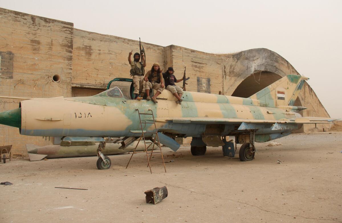 Members of Al-Qaeda's Syrian affiliate and its allies sit on top of a Syrian fighter jet after they seized the Abu Duhur military airport earlier this month.