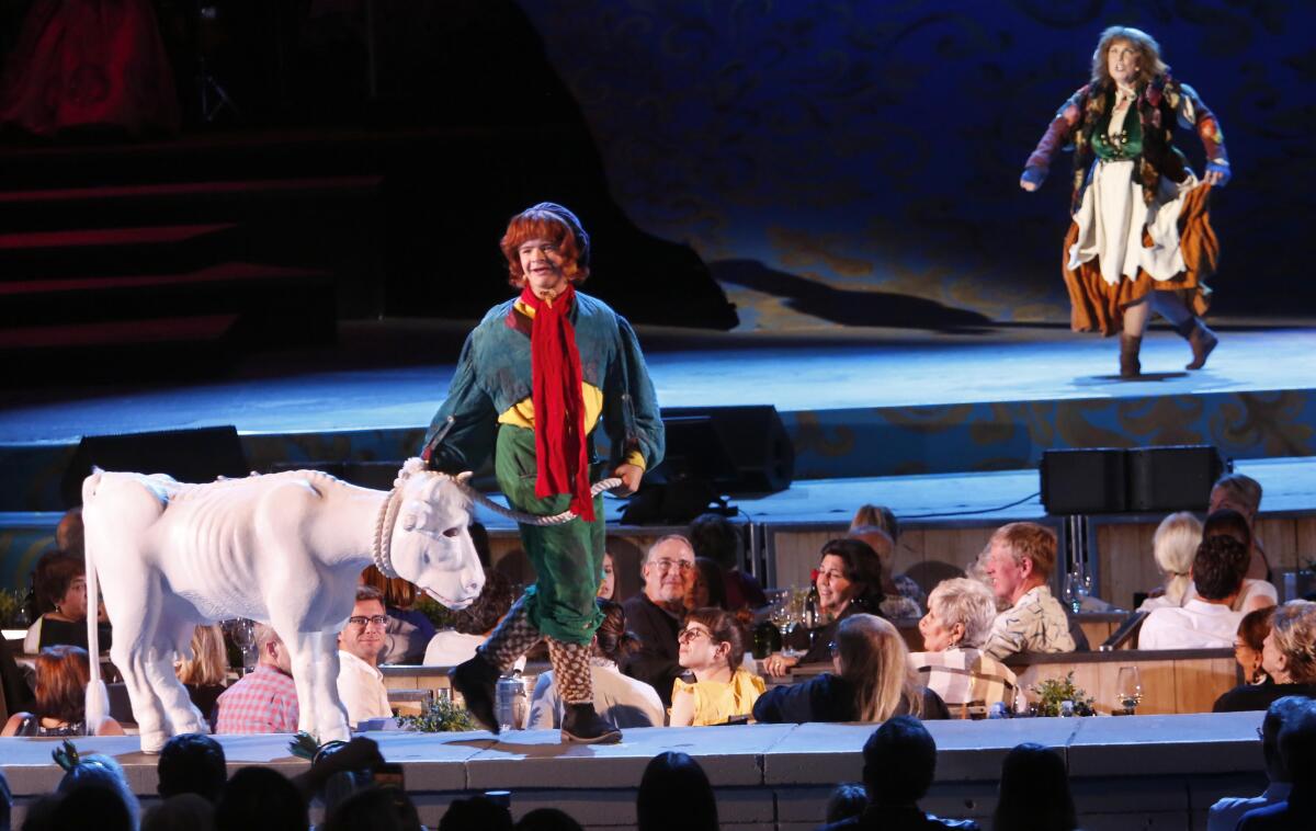 Gaten Matarazzo, onstage with a faux calf, is Jack in the Hollywood Bowl production of "Into the Woods" in July. In the background: Rebecca Spencer as Jack's mother.