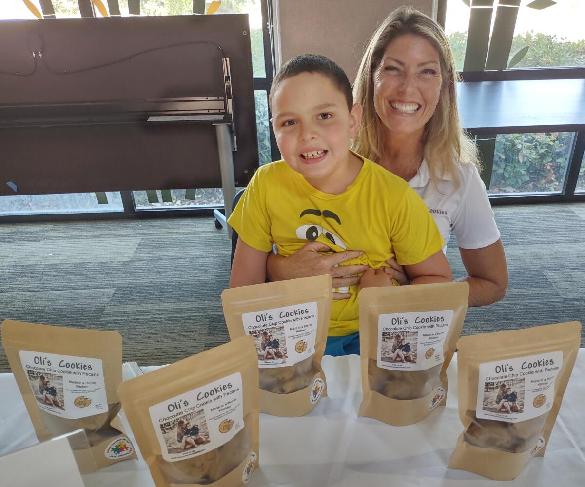 Poway resident Laura Bache sells cookies with the help of her 8-year-old autistic son, Oliver.