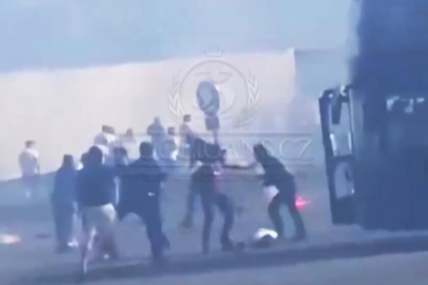 In this photo taken from video released by Hooligans.cz, people dressed in black fight against people dressed in white, near Fresnes-Les-Montauban, France, Saturday, May 25, 2024. Lyon and Paris Saint-Germain supporters clashed on a highway leading to the venue of the French Cup final a few hours before kickoff on Saturday.(Hooligans.cz via AP)