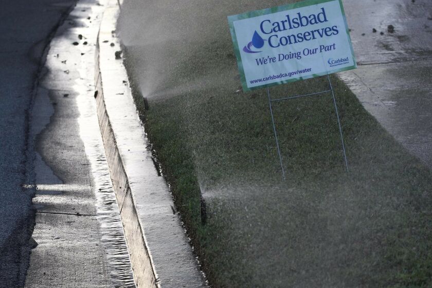 Sprinklers go off in an industrial park off of Palomar Airport Road in Carlsbad. The city is cutting its watering schedule to once a week beginning Dec. 1.