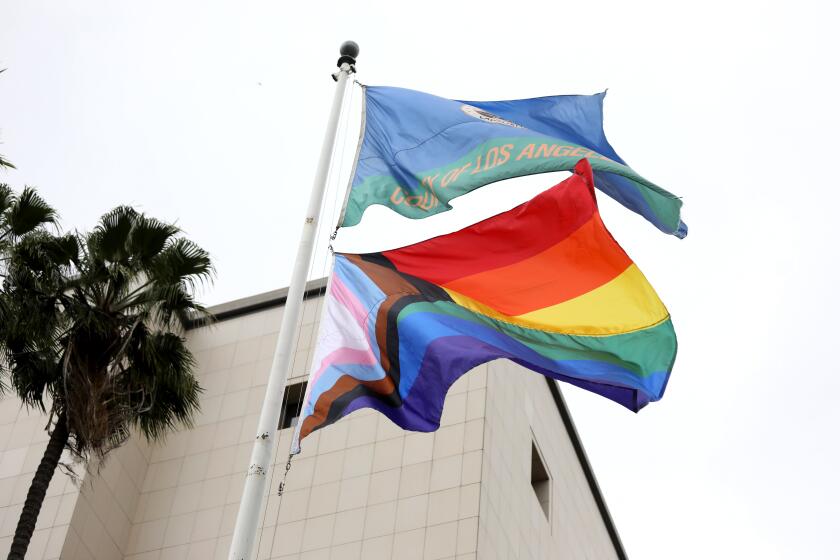 LOS ANGELES, CA - JUNE 01: The Progress Pride Flag flies over the Kenneth Hahn Hall of Administration for the first time in downtown on Thursday, June 1, 2023 in Los Angeles, CA. L.A. County Supervisors Janice Hahn, Hilda Solis, Kathryn Barger and Lindsey Horvath will join county Assessor Jeff Prang, and Sister Tootie Toot of the group the L.A. Sisters of Perpetual Indulgence to raise the Progress Pride Flag over the Kenneth Hahn Hall of Administration. It will mark the first time a pride flag has flown over a county building. (Gary Coronado / Los Angeles Times)