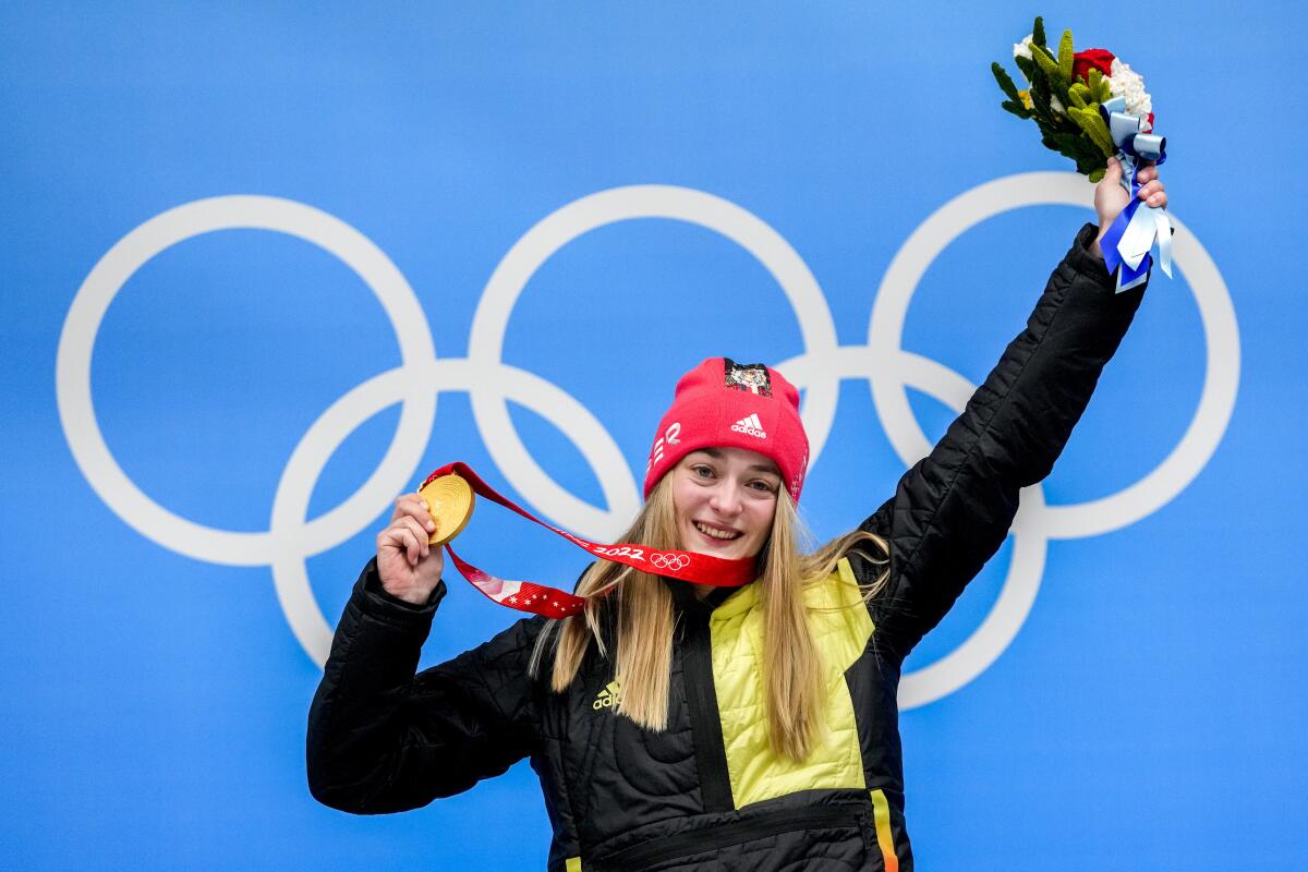 Hannah Neise holds up her gold medal for women's skeleton at the 2022 Olympics