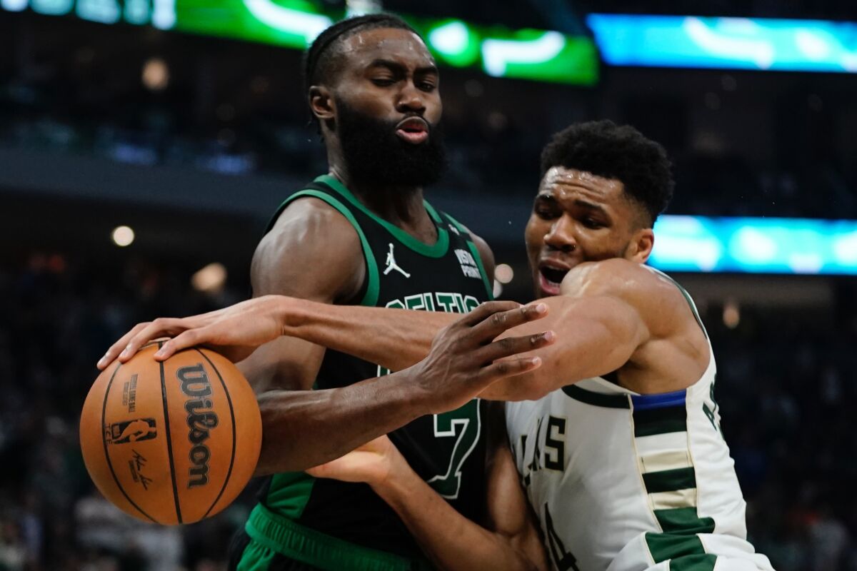 Bucks forward Giannis Antetokounmpo and Celtics forward Jaylen Brown get tangled as they battle for a loose ball.